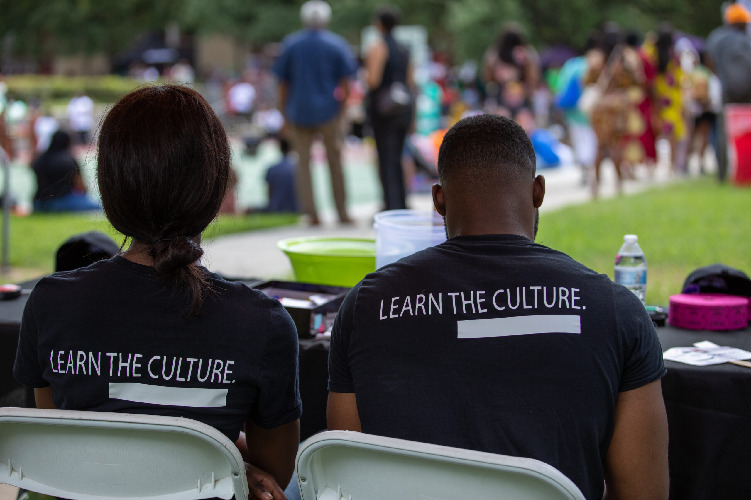 The words learn culture on the back on a t-shirt at a festival